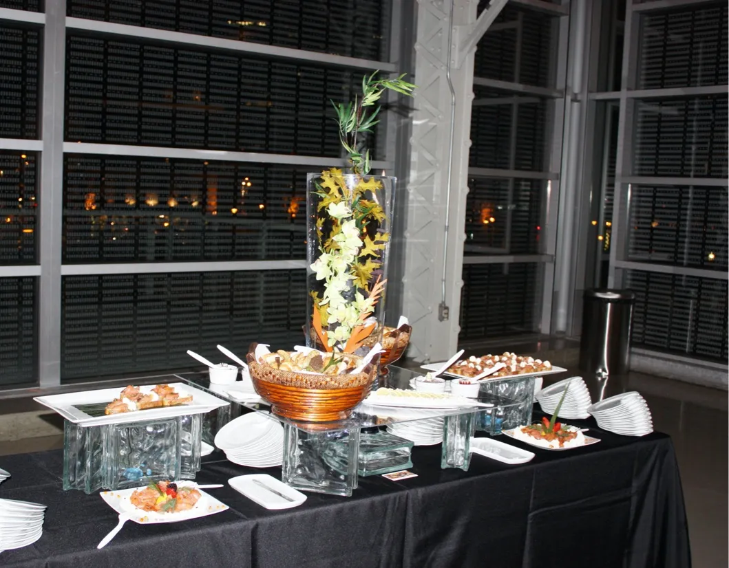 Table de buffet avec bouchées raffinées et décor floral, préparée par un traiteur événementiel pour une réception corporative à Montréal