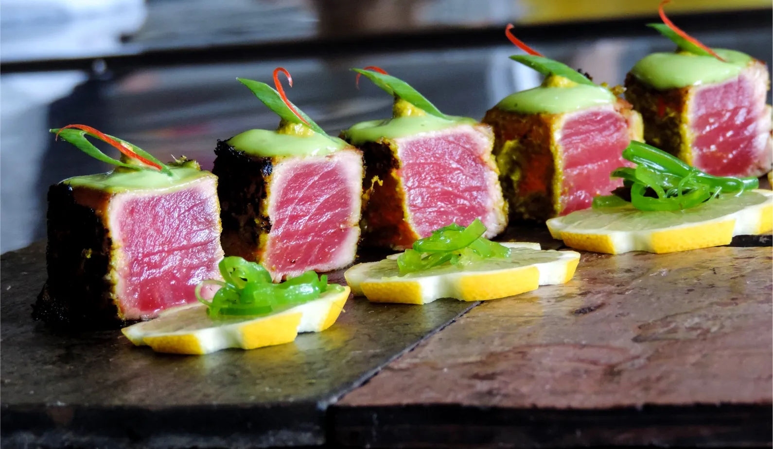 Pavé de thon saisi en croûte servi avec citron et sauce verte, proposé dans un menu de traiteur événementiel haut de gamme pour réception à Montréal